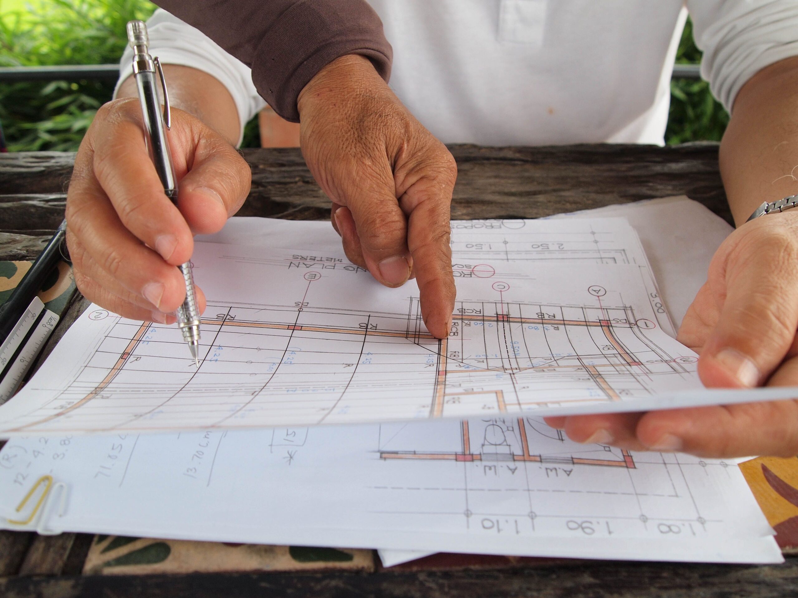 Hands reviewing construction blueprint